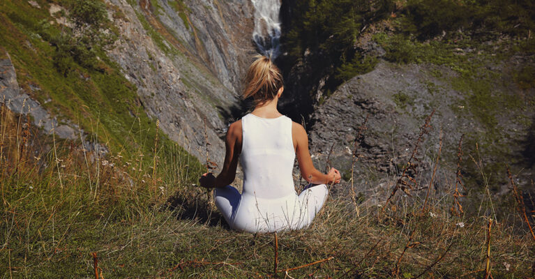 Woman meditating in the hills