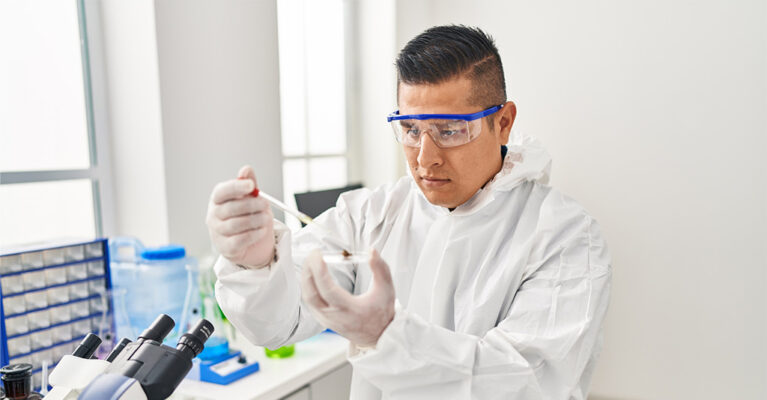 Lab technician observing cannabis in beaker for entourage effect