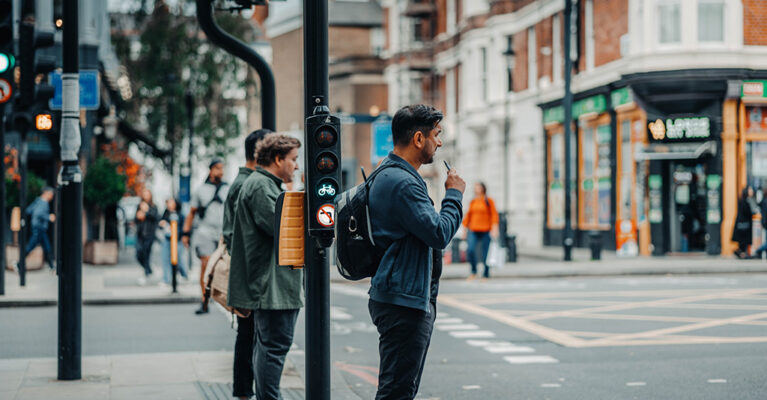 People waiting at a traffic light.