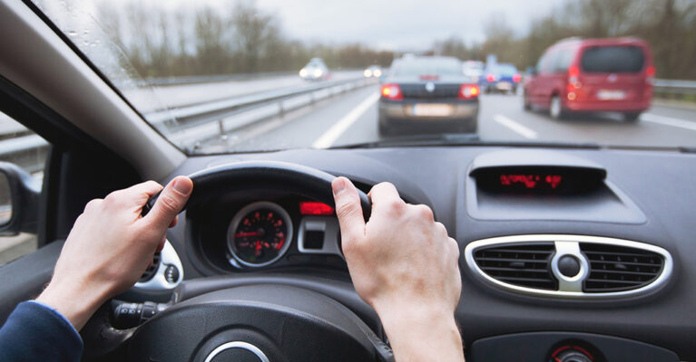 Hands on steering wheel, traffic ahead
