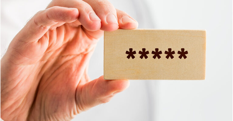 Hand holding wooden block with asterisks