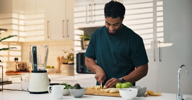 Person chopping fruits in kitchen.